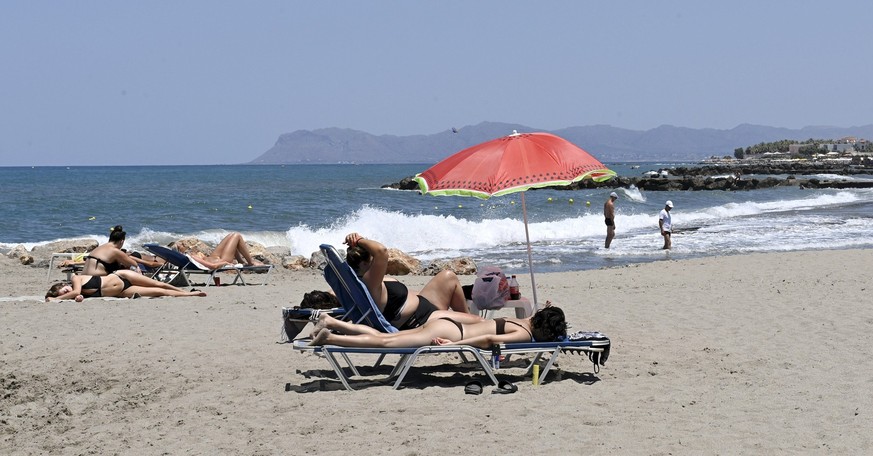 06.07.2022, Griechenland, Chania: Touristen sonnen sich an einem Strand auf der Insel Kreta. Foto: Heikki Saukkomaa/Lehtikuva/dpa +++ dpa-Bildfunk +++