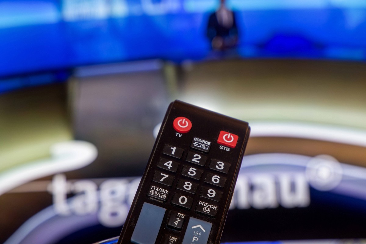 Symbolbild Rundfunkbeitrag, Beitragsservice, ARD: Nahaufnahme einer Fernbedienung vor einem Fernsehger�t *** Symbolic image broadcasting fee, contribution service, ARD Close-up of a remote control in  ...