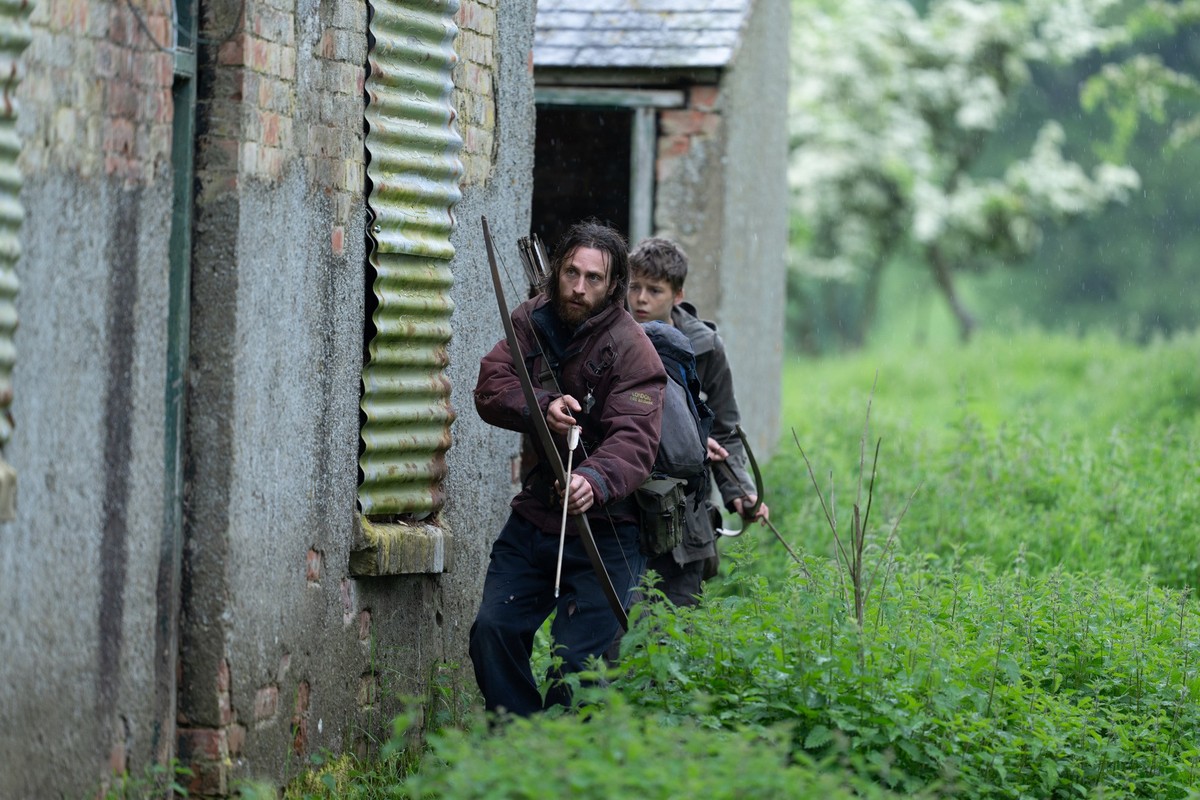 ACHTUNG: SPERRFRIST 18. JUNI 23:00 UHR. - HANDOUT - 12.06.2025, ---: Aaron Taylor-Johnson als Jamie (vorn) und Alfie Williams als Spike in einer Szene des Films "28 Years Later" (undatierte ...