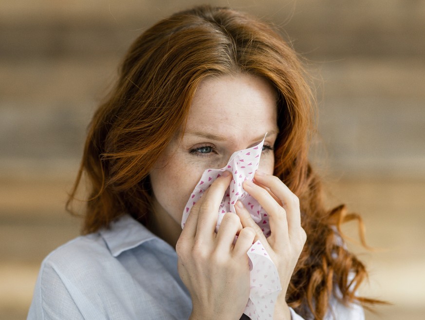 Redheaded woman blowing nose model released Symbolfoto property released PUBLICATIONxINxGERxSUIxAUTxHUNxONLY KNSF06530
