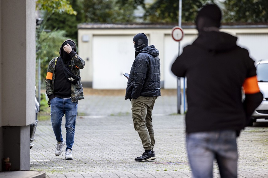 24.10.2023, Nordrhein-Westfalen, Duisburg: Drei Polizeibeamte stehen nach der Festnahme des Verd