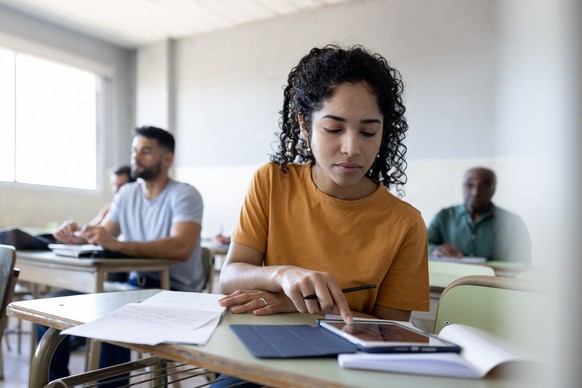 Latin American female college student using a tablet computer in class - education concepts