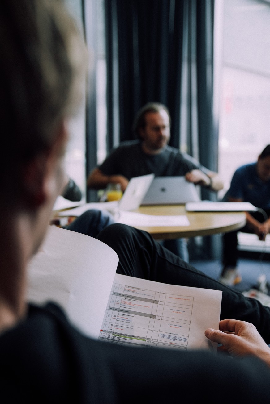 Alex Schlüter studiert ein Handout zum Ablauf der Sendung.