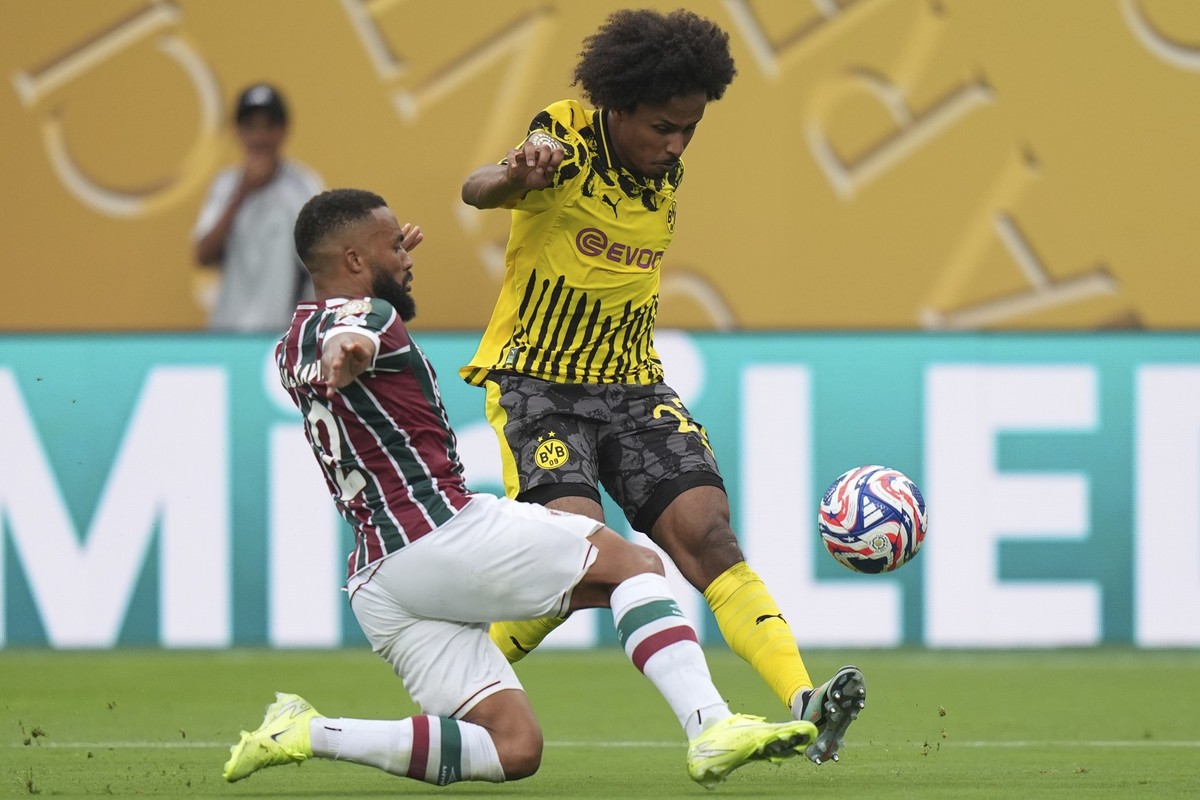 Borussia Dortmund's Karim Adeyemi takes a shot as Fluminense's Samuel Xavier defends during the Club World Cup group F soccer match between Fluminense and Borussia Dortmund in East Rutherfor ...