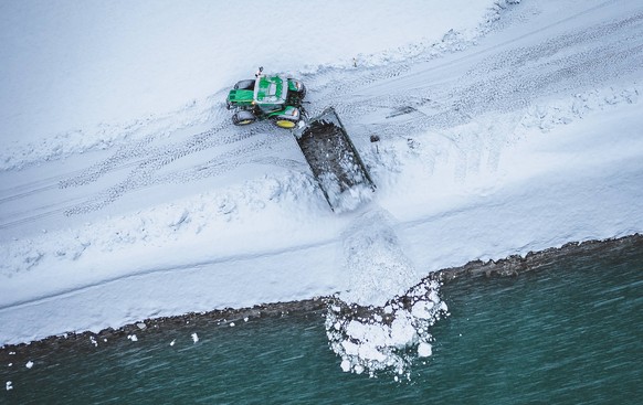 Bruck an der Glocknerstrasse THEMENBILD - ein Traktor aedt geraeumten Schnee in die Salzach ab, aufgenommen am 08. Jaenner 2019 in Bruck an der Glocknerstrasse, Oesterreich // a tractor loads cleared ...