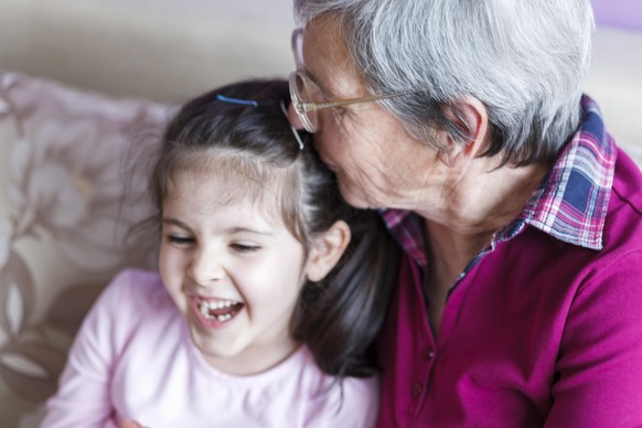 Grandmother kissing her grandaughter&#039;s head