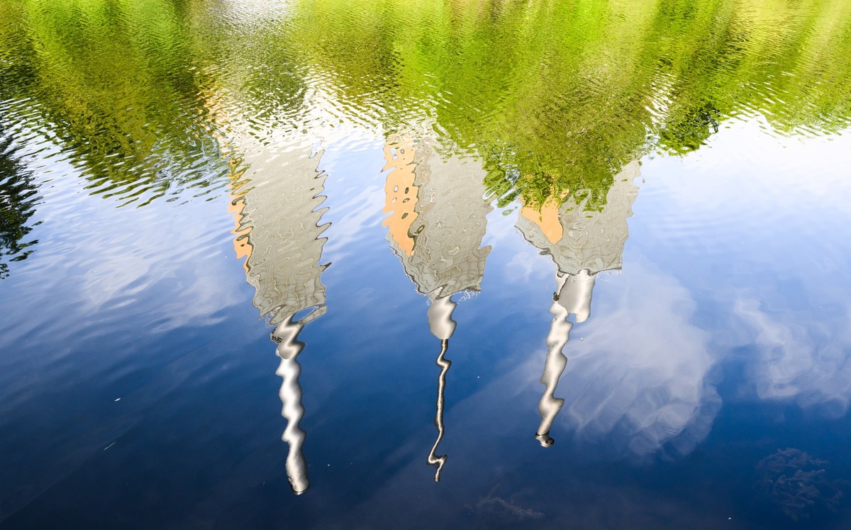 ARCHIV - 04.08.2022, Niedersachsen, Hannover: Das Heizkraftwerk Linden (&quot;Die drei warmen Br�der&quot;) spiegelt sich im Fluss Ihme. Viele Gaskraftwerke - wie auch das enercity Gaskraftwerk Linden ...