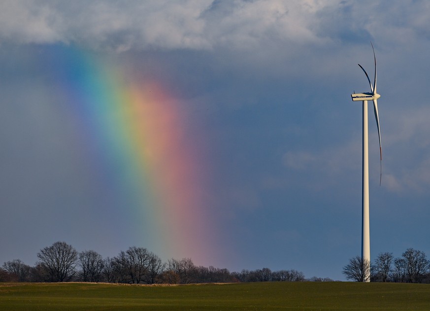 ARCHIV - 11.03.2021, Brandenburg, Alt Zeschdorf: Ein Regenbogen ist vor dunklen Wolken am Himmel