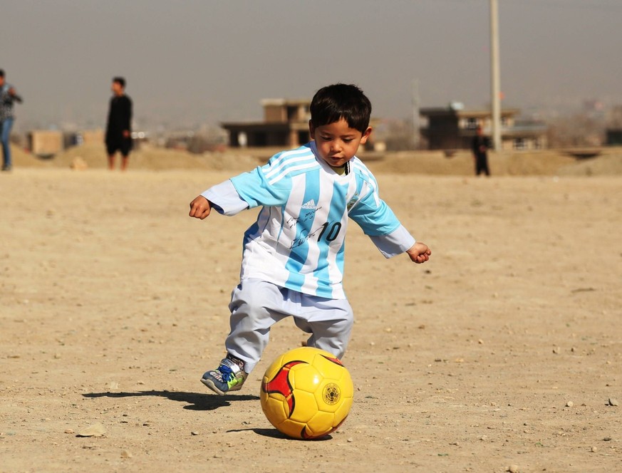 (160226) -- KABUL, Feb. 26, 2015 -- Afghan boy Murtaza Ahmadi plays football wearing a new jersey signed by Argentina soccer star Lionel Messi of Spanish Barcelona FC in Kabul, capital of Afghanistan, ...