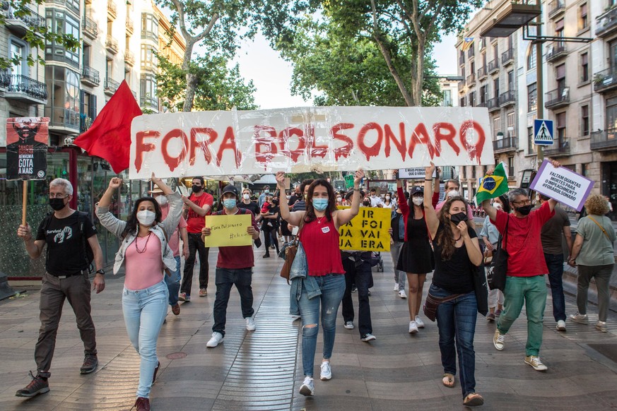 May 29, 2021, Barcelona, Spain: Protesters with a banner that reads, Get out Bolsonaro, during the demonstration..On the day marked by demonstrations in the main cities of Brazil against the Brazilian ...