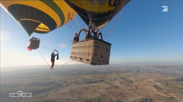 Schauspielerin Nilam Farooq balanciert in 300 Metern Höhe über ein Band von einem Ballon zum anderen.