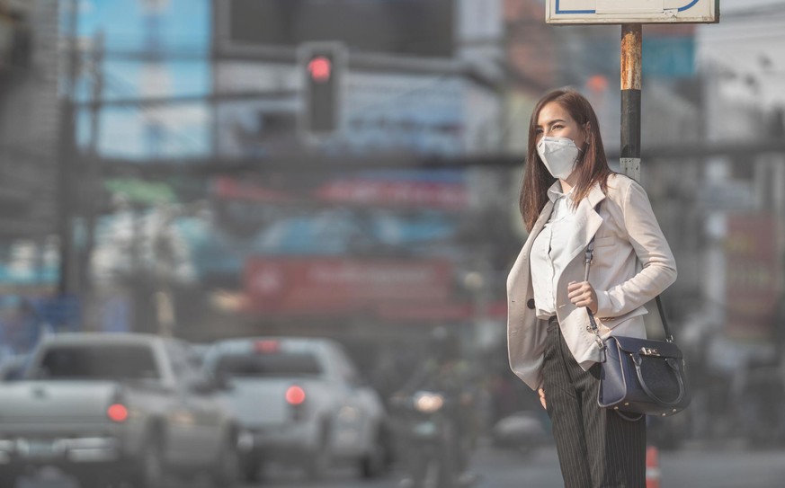 Asian woman are going to work.she wears N95 mask.Prevent PM2.5 dust and smog