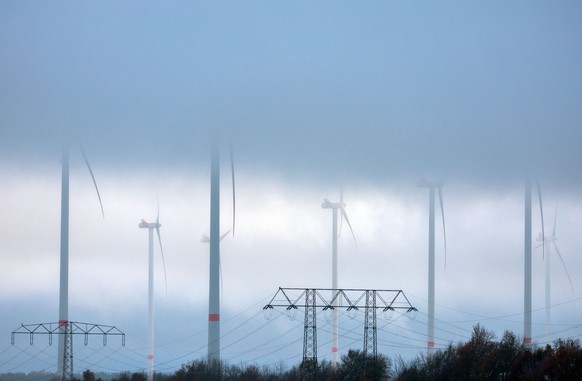 08.12.2022, Mecklenburg-Vorpommern, Parchim: Tief hängende Wolken ziehen über Anlagen in einem Windpark. Mit Nebel, Temperaturen um die null Grad und Schneeregen zeigt sich das Winterwetter in Norddeu ...