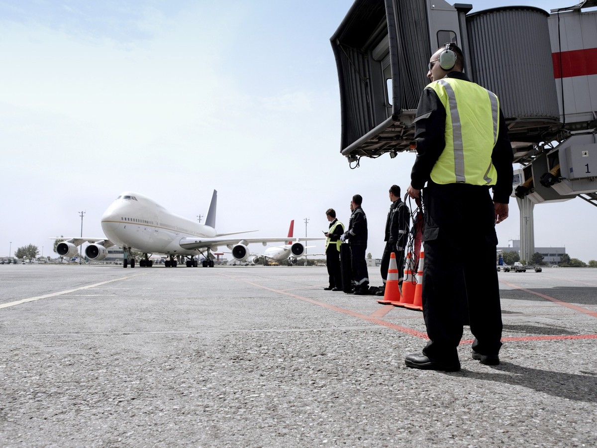 Airport ground control workers waiting for a airplane marshalling in an airport