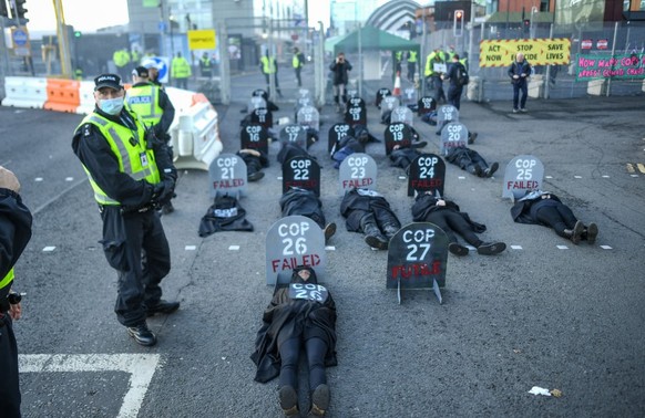 GLASGOW, SCOTLAND - NOVEMBER 13: Extinction Rebellion protesters are seen during a die in protest outside the entrance to the COP26 site on November 13, 2021 in Glasgow, United Kingdom. As delegates i ...