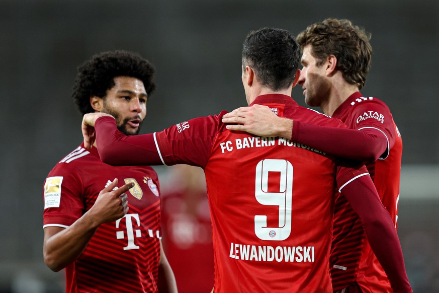 Fußball: Bundesliga, VfB Stuttgart - Bayern München, 16. Spieltag, in der Mercedes-Benz-Arena. Münchens Robert Lewandowski (M) jubelt mit Münchens Thomas Müller (r) und Münchens Serge Gnabry über sein ...