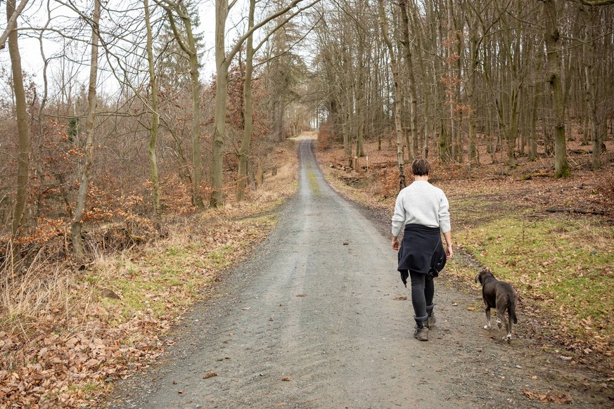 Herbstliche Winterwanderung: Frau und Hund im Wald 10.02.24, Selters: Symbolfoto, Illustrationsbild, Symbolbild, Illustrationsfoto Herbstliche Winterwanderung: Frau und Hund im Wald Eine Frau genießt  ...