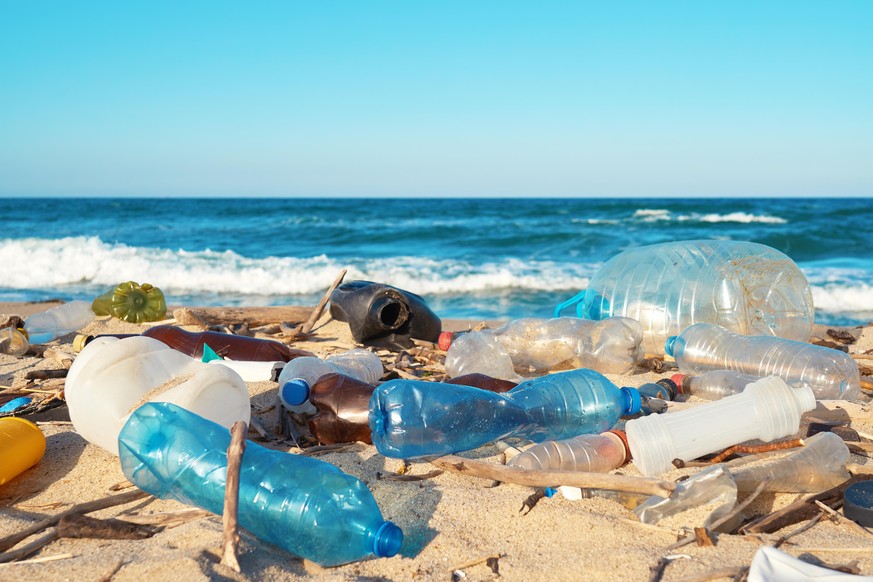 Spilled garbage on the beach of the big city. Empty used dirty plastic bottles. Empty used dirty plastic bottles. Dirty sea sandy shore of the Black Sea. Environmental pollution. Ecological problem