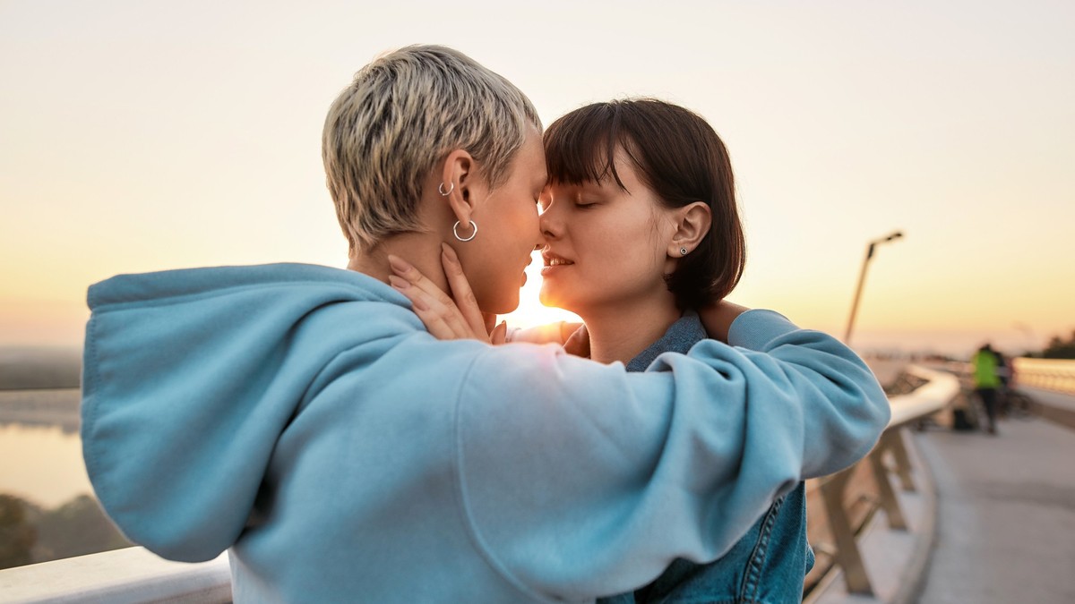 Young passionate lesbian couple going to kiss, Two women enjoying romantic moments together at sunrise, Selective focus, Side view, Web Banner