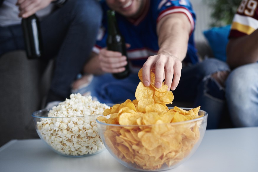 Close up of mens hand grabbing chips