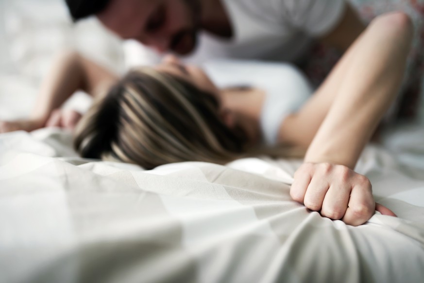 Young attractive happy couple having romantic time in bed