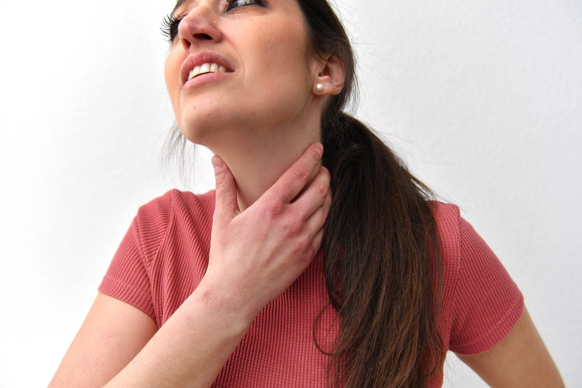 Themenbild,Symbolfoto Schmerzen. Eine junge Frau haelt sich ihren Hals. Halskratzen,Lymphknoten,Halsschmezen, Model Released *** Theme Image,Symbol Photo Pain A young woman holds her neck scratching,l ...
