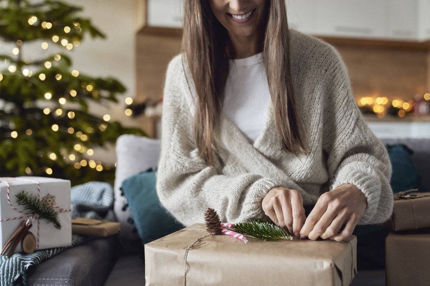Smiling woman wrapping gift at home model released, Symbolfoto property released, ABIF01716