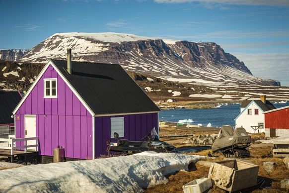 QEQERTARSUAQ, DENEMARKEN - 18 juni 2015: Een gekleurd huis in Qeqertarsuaq op het eiland Disko met uitzicht op de bergen en de Diskobaai op de achtergrond xkwx Groenland, Groenland 2015, Qeqertarsuaq, Disko ...