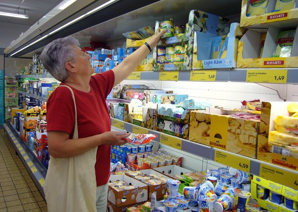 ARCHIVFOTO: Ab dem 2.4.2022 faellt die Maskenpflicht beim Einkaufen, Aeltere Frau beim Einkaufen bei Aldi Sued,Aldi Filiale,Discounter,Einkaufswagen,Regale,Lebensmitttel,Filiale.Konsum,Konsumgueter.Ei ...