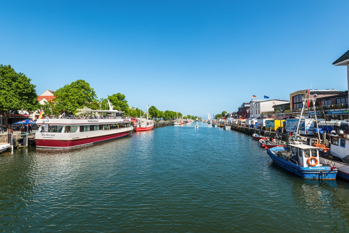 Boats in Warnemunde, Rostock, Mecklenburg-Western Pomerania, Germany, Rostock, Germany - May 26, 2017: Colorful harbor tour ship and fishing boats resting in the peaceful Alter Strom Canal on this spr ...