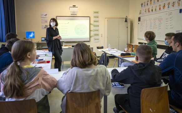 Schülerinnen und Schüler einer neu eingerichteten Willkommensklasse für aus der Ukraine geflüchtete Kinder am Lessing-Gymnasium sitzen in einem Klassenraum an ihren Tischen. Im Hintergrund steht die K ...