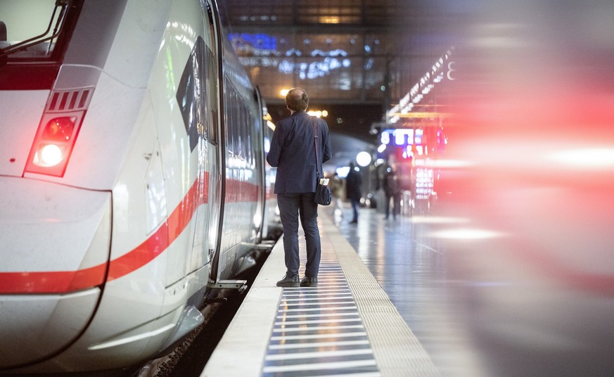 28.02.2023, Hessen, Frankfurt/Main: Ein Zugbegleiter steht am Hauptbahnhof an einem ICE. In Fulda findet am 28. Februar der Auftakt der Tarifverhandlungen zwischen der Gewerkschaft EVG und der Deutsch ...