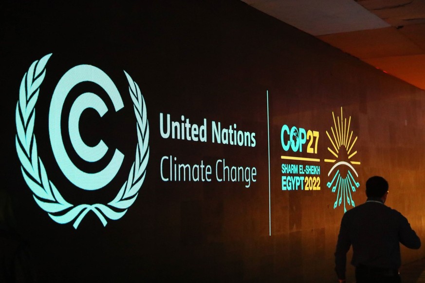 A man walks past a board showing the 27th Conference of the Parties of the United Nations Framework Convention on Climate Change (COP27) in Sharm El-Sheikh, Egypt, Nov. 5, 2022. The COP27 is to be hel ...