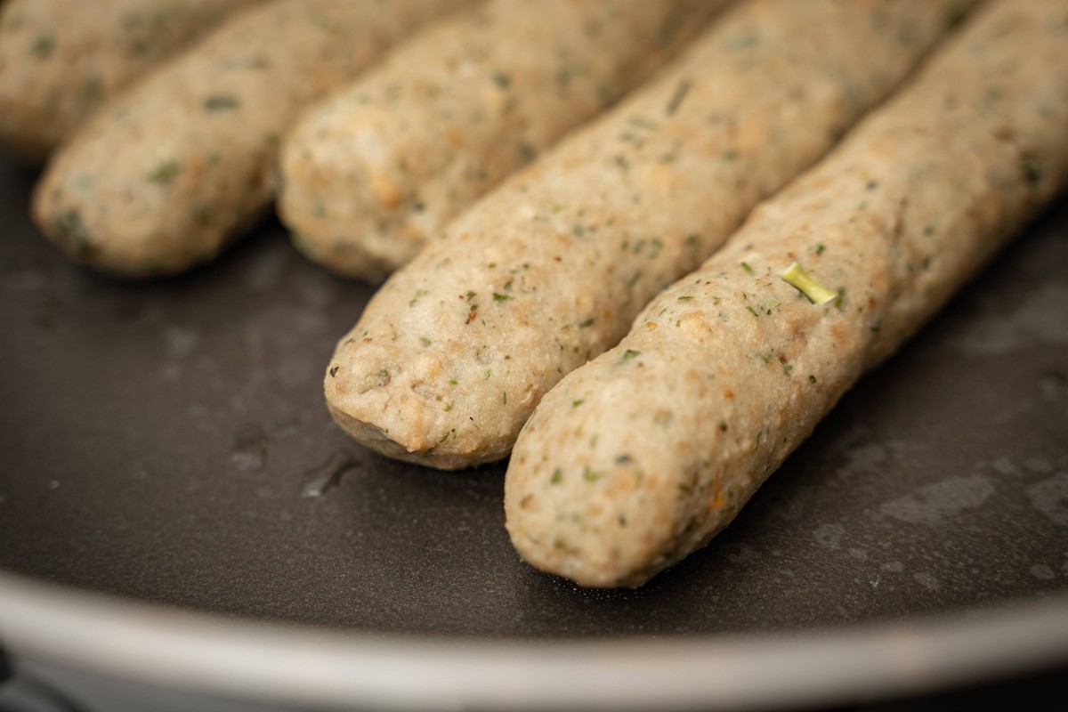 10 February 2022: Vegan sausage in a pan. Meat substitute made from pea protein and wheat protein. Bratwurst in a frying pan *** Vegane Bratwurst in einer Pfanne. Fleischersatz aus Erbsenprotein und W ...