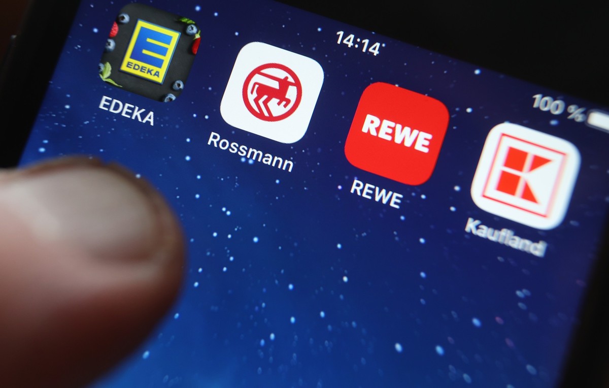 ILLUSTRATION - 02.12.2022, Bayern, Kaufbeuren: Icons der Apps von den Handelsketten Edeka (l-r), Rossmann, REWE und Kaufland sind auf dem Display eines iPhones zu sehen. Wer angesichts der Inflation b ...