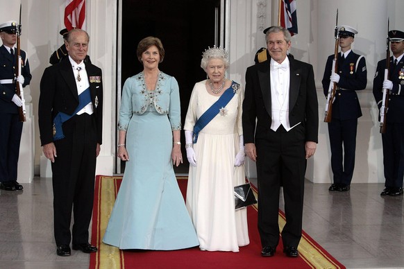 On official occasions, the Queen often wears a white gown with gloves and a blue sash, as seen here when she met US President George W. Bush in 2007. 