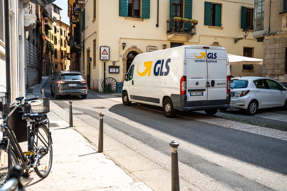 Verona, Italy - 13 May 2022: A GLS Transporter parcel service drives through the narrow streets of Verona, Italy *** Ein GLS Transporter Paketdienst fährt durch die engen Straßen von Verona in Italien