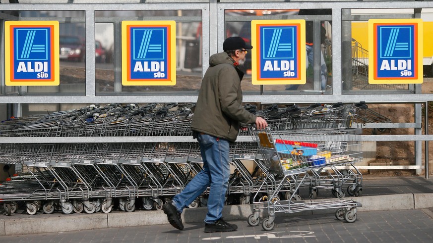 RUESSELSHEIM, GERMANY - APRIL 8: A shopper pushs a shopping cart outside an Aldi store on April 8, 2013 in Ruesselsheim near Frankfurt, Germany. Aldi, which today is among the world’s most successful  ...