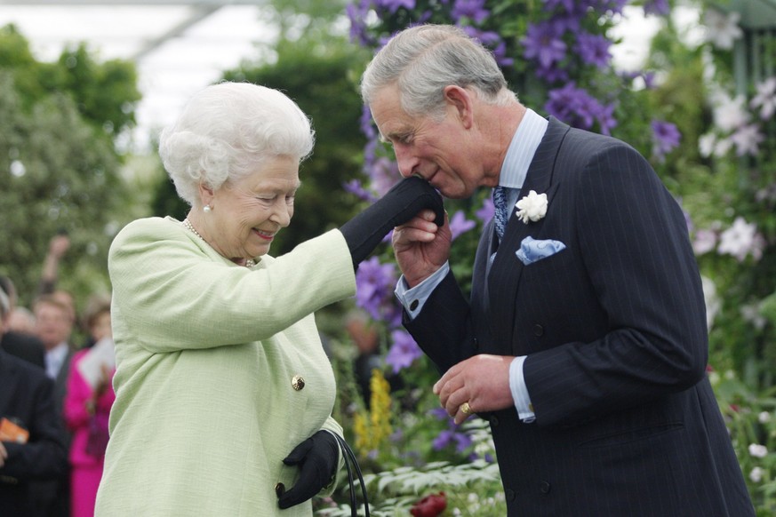LONDON - MAY 18: Queen Elizabeth II presents Prince Charles, Prince of Wales with the Royal Horticultural Society&#039;s Victoria Medal of Honour during a visit to the Chelsea Flower Show on May 18, 2 ...