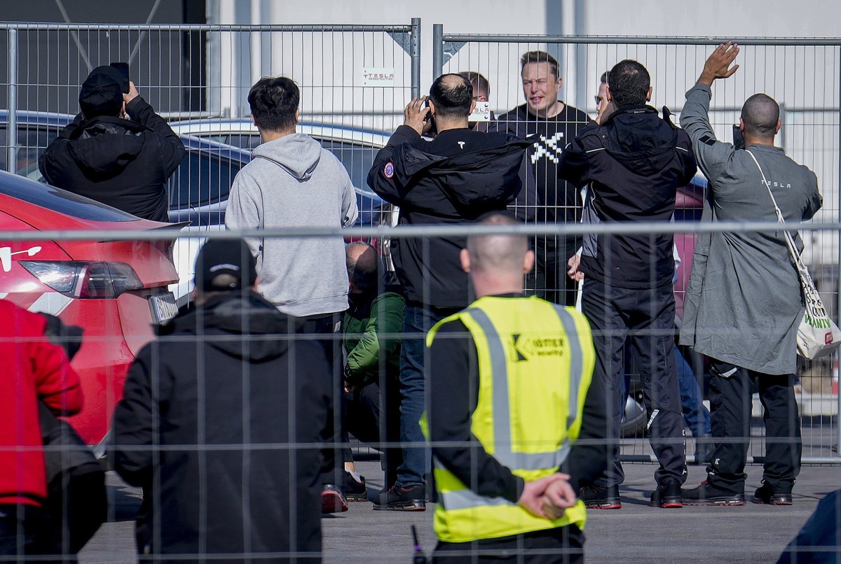 Tesla CEO Elon Musk, 4th from right, arrives at the Tesla Gigafactory for electric cars in Gruenheide near Berlin, Germany, Wednesday, March 13, 2024. Power has been restored to electric car manufactu ...