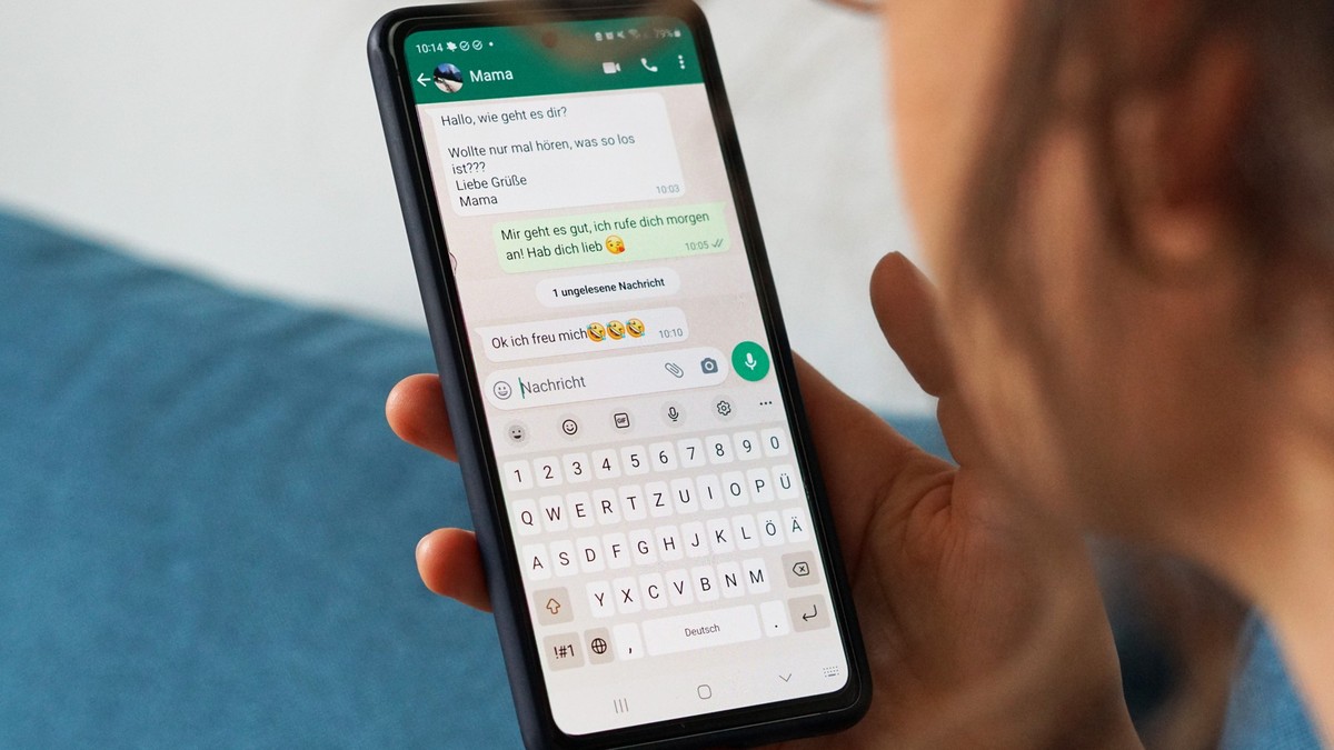 ILLUSTRATION - 29.09.2023, Berlin: Eine junge Frau hält ihr Smartphone in der Hand und liest eine Whatsapp-Nachricht von ihrer Mama. (zu dpa: «Der Smiley-Effekt: Wie Emojis empfundene Nähe steigern»)  ...