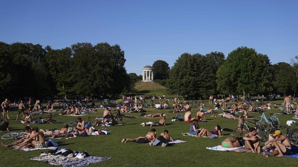 People enjoy the hot summer weather at the &#039;Englischer Garten&#039; park in Munich, Germany, Wednesday, Aug. 3, 2022. (AP Photo/Matthias Schrader)