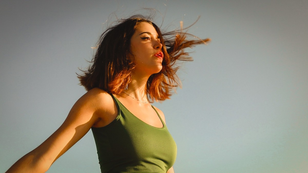 Beautiful young woman breathing with her hair in the wind