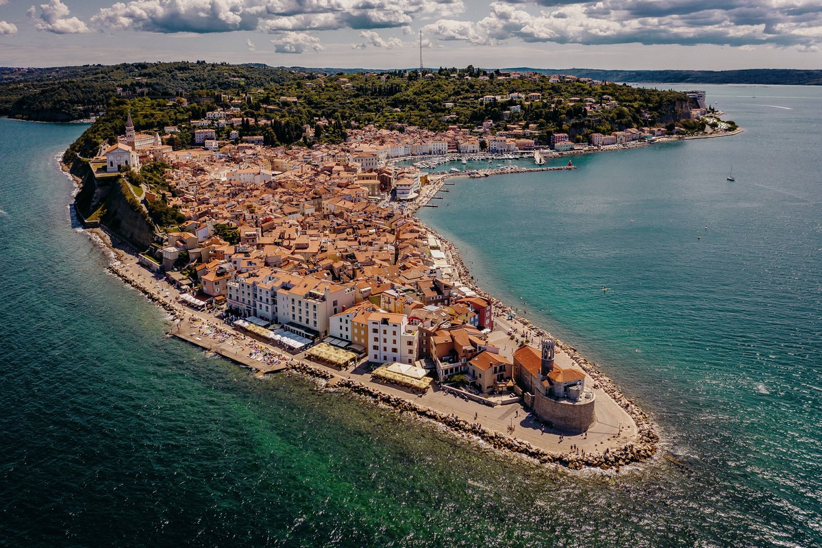 Piran THEMENBILD - Blick auf die Altstadt und den historischen Gebaeuden mit den Badestraenden, aufgenommen am 16. August 2019 in Piran, Slowenien // View of the old town and the historic buildings wi ...
