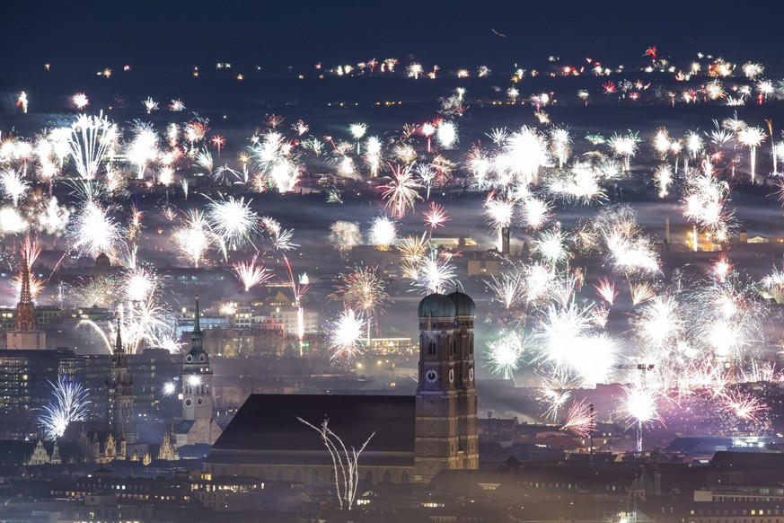 ARCHIV - 01.01.2023, Bayern, München: Silvesterfeuerwerk ist zum Jahreswechsel über der Kulisse der Stadt zu sehen. Um das private Feuerwerk auch aus Umweltgründen einzudämmen, gibt es in der Stadt Üb ...