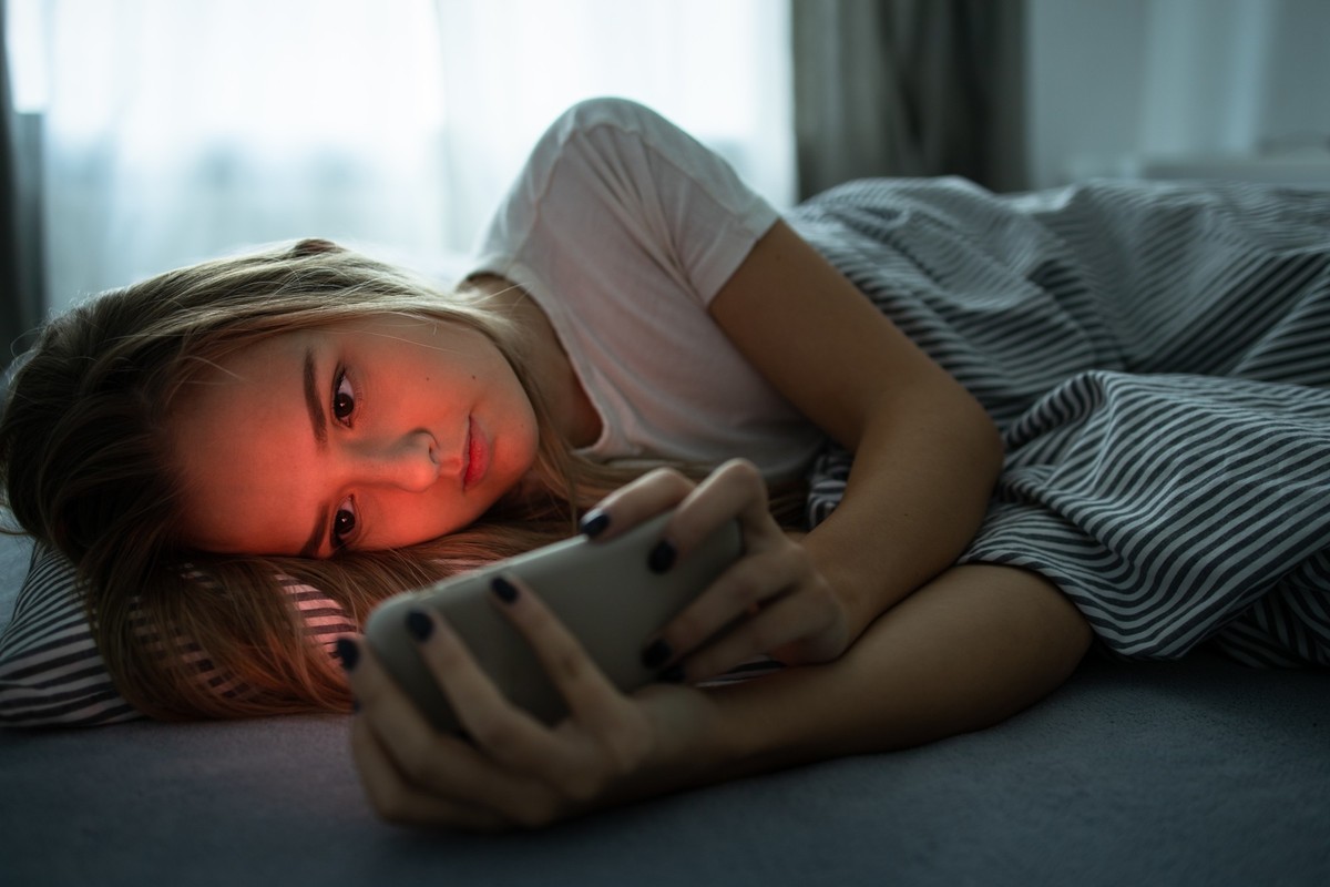 Pretty, young woman sleeping in her bed with her cell phone close to her. Smartphone in Bed Mobile/smartphone Addiction Concept. model released, Symbolfoto, 26.02.2020 09:04:35, Copyright: xLightpoetx ...