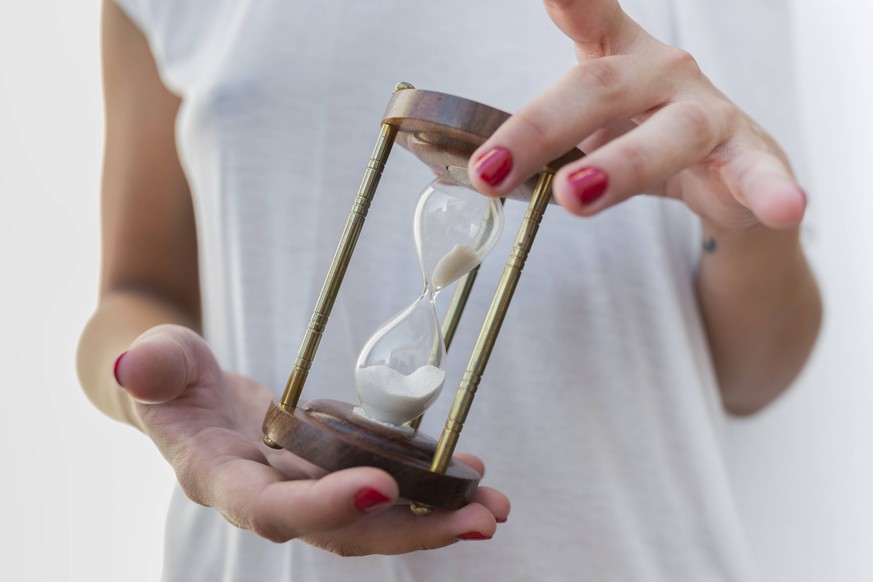 Woman s hands holidng an hourglass model released Symbolfoto PUBLICATIONxINxGERxSUIxAUTxHUNxONLY JPTF00029