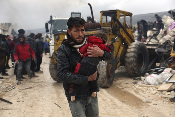 A man carries the body of an earthquake victim in the Besnia village near the Turkish border, Idlib province, Syria, Monday, Feb. 6, 2023. (AP Photo/Ghaith Alsayed)