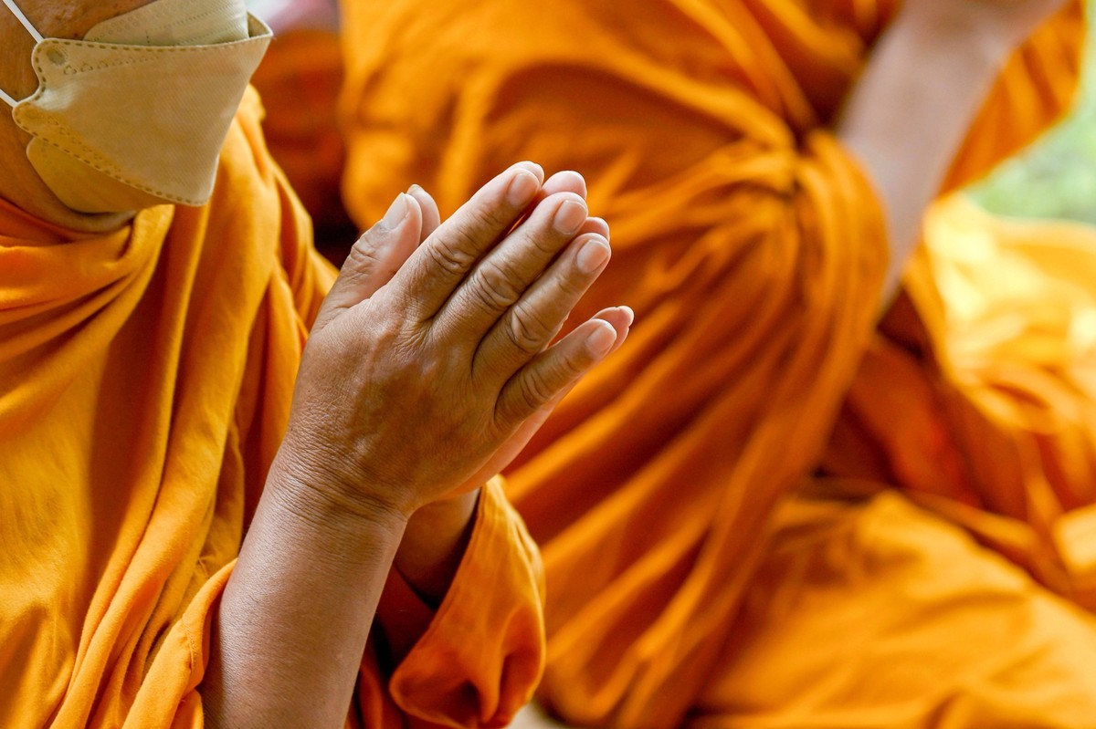 September 9, 2022, Bangkok, Thailand: A close up view of a Thai monk s wai, the clasping of hands in prayer. Thai Buddhist monks perform a Tam Boon blessing ceremony at a new opened business Caf 123 i ...