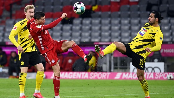 Fußball: Bundesliga, FC Bayern München - Borussia Dortmund, 24. Spieltag in der Allianz Arena. Dortmunds Mittelfeldspieler Emre Can (r-l) und Münchens Stürmer Robert Lewandowski neben Dortmunds Mittel ...